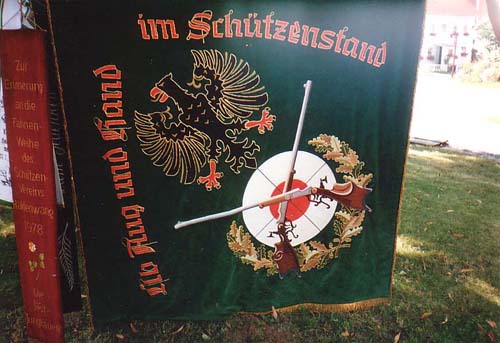 Schießscheibe mit überkreuzten Luftgewehren mit dem Schriftzug „Üb Aug und Hand im Schützenstand“